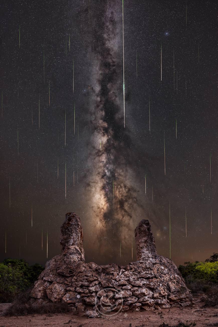 Lluvia de estrelals de las Perseidas con la Vía Láctea emergiendo desde un pozo de roca conocido como Es Pou Salat.