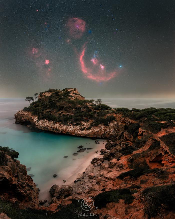 Night view from Caló des Moro in Mallorca with the Orion constellation above the sea and rocky formations in the foreground
