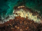 Foto aérea de sedas de agua sobre roca erosionada en Cap de Salines, Mallorca — un segundo de exposición al atardecer