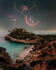 Vista nocturna desde Caló des Moro en Mallorca con la constelación de Orión sobre el mar y formaciones rocosas en primer plano