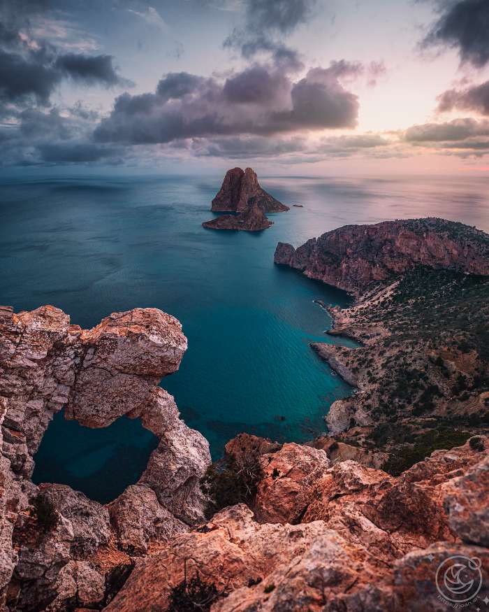 Vista de l'illot d'Es Vedrà des de l'Ull d'Es Vedrà a Eivissa, al capvespre, amb el mar i el cel en calma